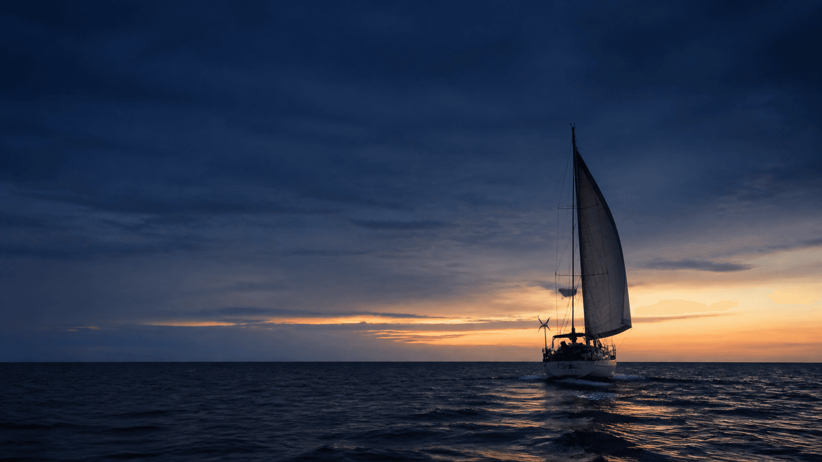 A quiet documentary-style view of hands, rope and navigation materials aboard a boat.